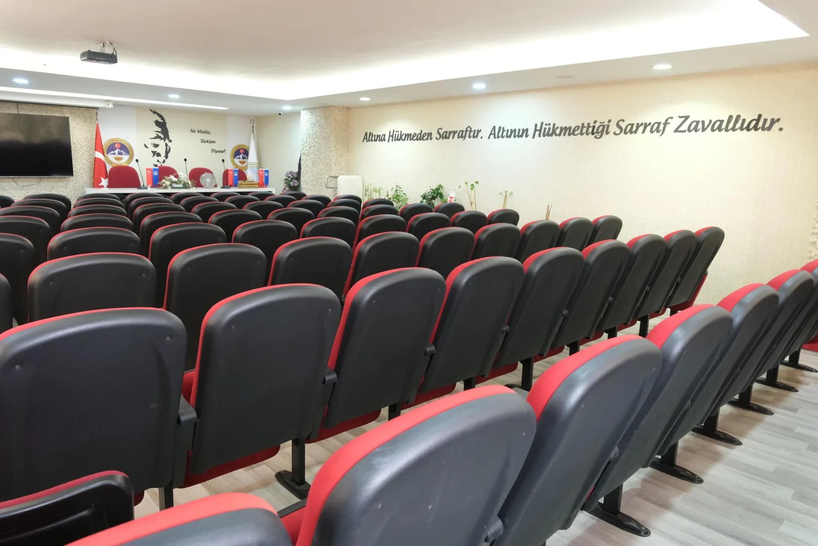 KAYSARDER konferans salonunun sahneye bakan siyah ve kırmızı koltuk düzeni